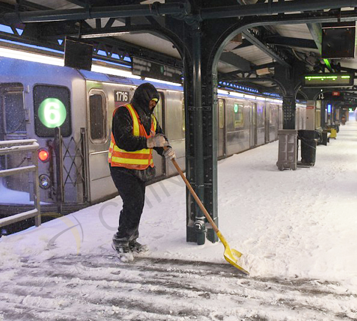 Sanitation workers in safety vest shoveling snow